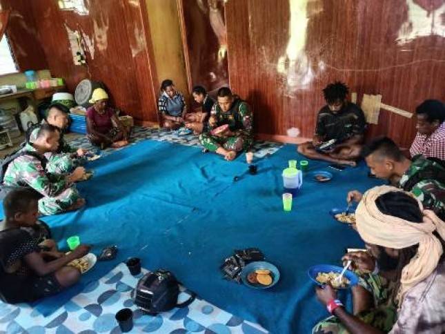 Satgas Yonif R 142 KJ Masak  dan Makan Bersama Warga dengan Makanan Khas TNI