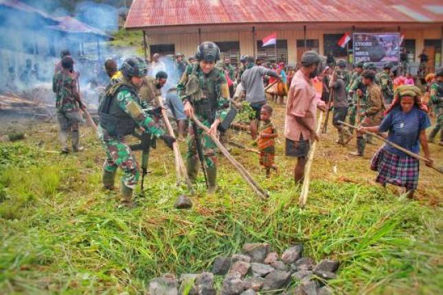 Prajurit Kostrad Bagikan Bahan Makanan dan Gelar Acara Bakar Batu di Pegunungan Papua