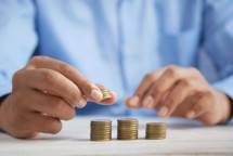 a person stacking coins on top of a table (Foto: Towfiqu barbhuiya / Unsplash)