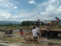 Petani sedang menurunkan alat mesin pertanian