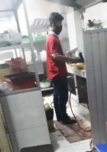 Salah satu anak buah pak Jumadi sedang mempersiapkan makanan siap saji. (Foto: Abraham Sihombing)