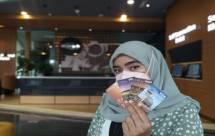 Nasabah menunjukkan kartu debit Bank Muamalat