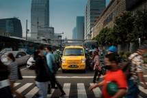 Kendaraan DHL berhenti di lampu merah dan nampak masyarakat lalu lalang menyebrang jalan