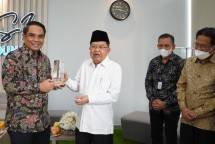 Direktur Sales & Distribution BSI Anton Sukarna (kiri pertama) menyerahkan secara simbolis buku tabungan BSI kepada Bendahara DMI Tatang Hidayat (kanan kedua) disaksikan langsung oleh Ketua Umum DMI Jusuf Kalla (kiri kedua) dan Ketua DMI Sofyan Djalil (kanan pertama pada peresmian Payment Point BSI di Gedung Kantor Pusat DMI di Matraman, Jakarta saat perayaan Milad Ke - 50 Dewan Masjid Indonesia 