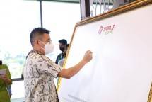 The Kim Hai (Chief Executive Officer) saat menandatangani komitmen bersama green corporate pada media kanvas. 
