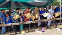 Dirut LLP-KUKM Emilia Suhaimi (dua dari kiri) dan Wali Kota Tangsel Airin Rachmi Diany membakar sate di Lapangan Giant BSD, Bintaro, Tangerang Selatan, mendadak ramai oleh ribuan anak yatim sejak Minggu (3/9). 