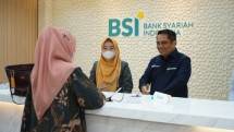 Direktur Sales & Distribution Bank Syariah Indonesia (BSI) Anton Sukarna berbincang dengan seorang nasabah setelah melakukan transaksi perbankan syariah di BSI Kantor Cabang Hasanudin, Jakarta Selatan. 