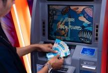 Nasabah BRI mengambil uang di mesin ATM