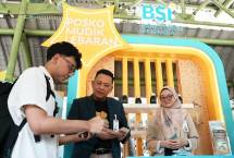 Direktur Retail Banking BSI Kemas Erwan Husainy menyapa pemudik yang singgah di Posko Mudik BSI di Stasiun Gambir.